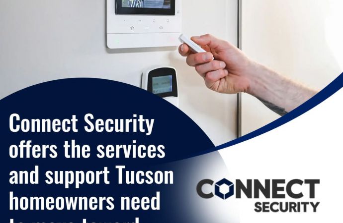 A hand holding a remote control pointing towards a smart home security display on a white wall. The display shows a live camera feed of a building exterior. Text on the image advertises "Connect Security" and their services for Tucson homeowners.