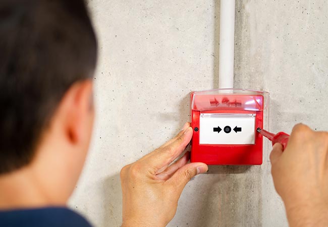 Electrician installing conventional fire alarm system