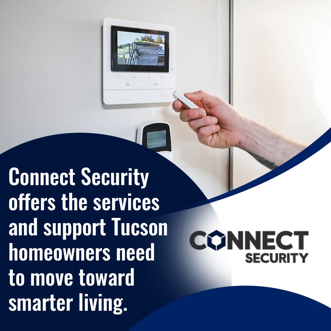 A hand holding a remote control pointing towards a smart home security display on a white wall. The display shows a live camera feed of a building exterior. Text on the image advertises "Connect Security" and their services for Tucson homeowners.