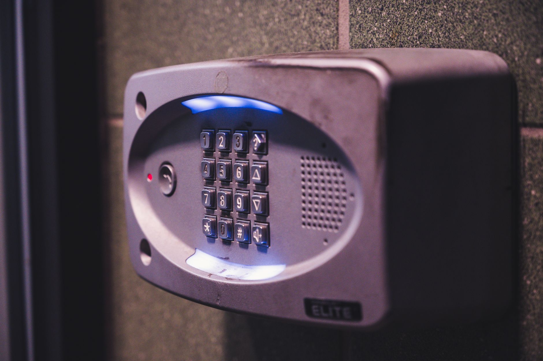 A modern home at dusk with visible security cameras mounted on corners, motion sensor lights illuminating the driveway, a